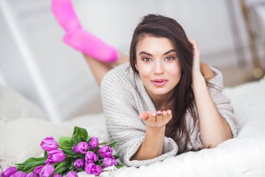 Çiçekli yatak odasında kapalı çekici genç kadın. Güzel kadın evde portresi. Erkek Lale ile kadeh yukarıya kapatmak.