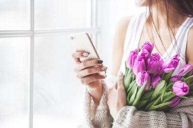 Evet ve gülümseyen tanınmaz halde genç çekici kadın. Güzel kız smartphone üzerinde tipik belgili tanımlık haber. Evde kapalı kadın.