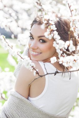 Bahar arka plan üzerinde genç güzel kadın portresi kapatın. Çekici kızı çiçekler. Model makyaj bahar.