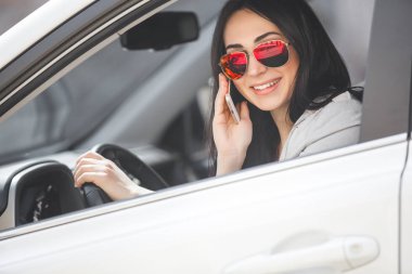 Çekici genç kadın car yakınındaki cep telefonunda söz. Kendine güvenen bayan cep telefonu sohbet ediyor. Otomobil içinde kadın.