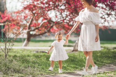 Onunla biraz şirin kızı açık yürüyüş genç çekici anne. Güzel aile niteliğine. Anne ve çocuğu eğleniyor.