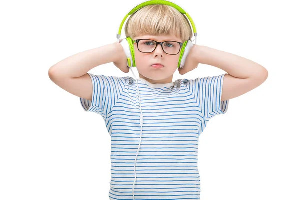 不幸な子供がイヤホンを着て音楽を聴きます 分離の白い背景の上にかわいい男の子 — ストック写真
