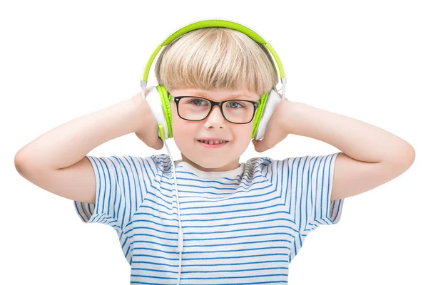 幸せな小さな子がヘッドフォンを身に着けています 分離の白い背景のイヤホンで音楽を聴くと 笑顔のかわいい男の子 — ストック写真
