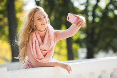 Cep telefonuyla konuşan genç bir kadın. Şirin bir bayan selfie çekiyor.