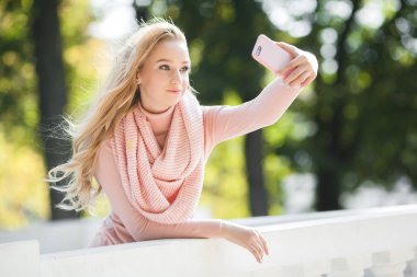 Dışarıda selfie çeken çekici genç kadın. Parkta cep telefonuyla konuşan sıradan bir kız. Çekici genç bayan cep telefonu ile arkadaşları ile sohbet.