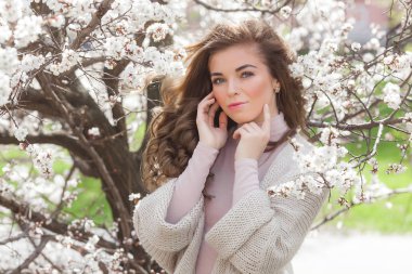 Bahar çiçekleri açık havada genç güzel kadın Closeup portre. Güzel kız. Mükemmel makyaj. Uzun kıvırcık saçlı sarışın bayan.