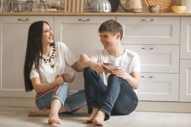 Genç çift mutfak eğleniyor. Birlikte yemek aile. Çekici bir adam ve mutfak arka plan üzerinde güzel kadın.