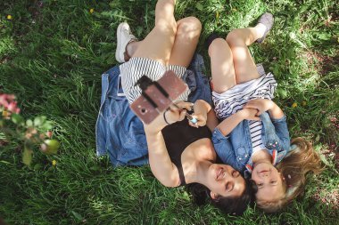 Genç anne ve kızı selfie cep telefonuna yapma. Cep telefonundan resim yapmak ve eğlenmek kızlar. Güzel kız. Anne ve çocuk açık.