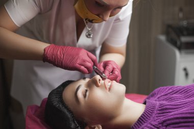 Kozmetolojist müvekkiline bir ingection yapıyor. Kadın güzellik prosedürü, dudak büyütme prosedürü. Antiaging tedavisi.