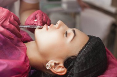 Kozmetolojist müvekkiline bir ingection yapıyor. Kadın güzellik prosedürü, dudak büyütme prosedürü. Antiaging tedavisi.