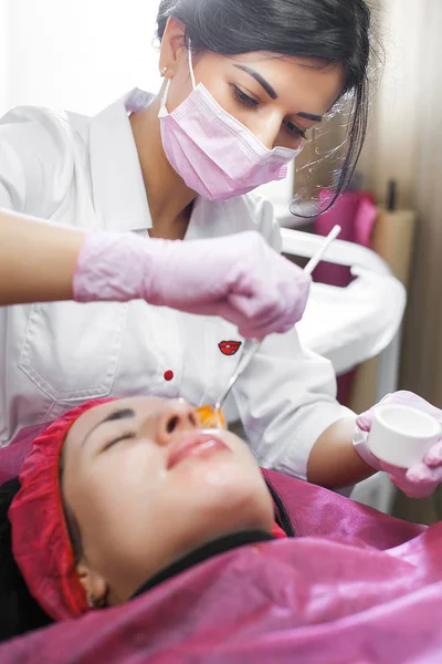 Cosmetologist making face lifting procedure. Dermatologist applying face mask. Beauty treatment in the clinic.