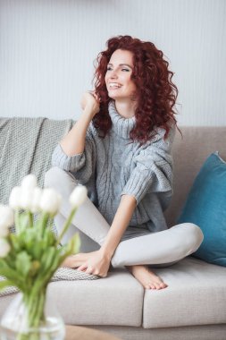 İçeride çok çekici bir genç bayan var. Kıvırcık saçlı kadın portresi. Evdeki kızıl saçlı güzel kadın..