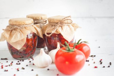 Kavanozdaki domatesler. Ev yapımı kurutulmuş domates. Geçici kapanma. Yaz ve sonbahar konserve yiyecekler. Baharat ve sebzelerle koru..
