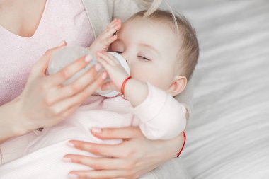 Küçük sevimli bebek formülü ile şişe emme. Mothe anne sütü ile onu küçük çocuk besleme.