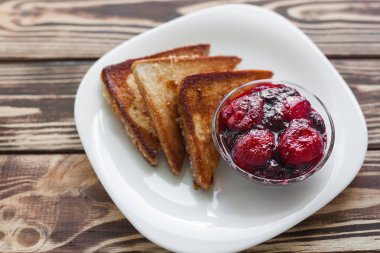 Sabah kahvaltısı. Çilek ve reçel ile tost. Ekmek ve sırdaş. Kremalı taze sıcak tostlar. Lezzetli ev yapımı tatlı.