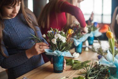 Çiçekçilikte yüksek lisans yapan kadınlar. Çiçek kompozisyonu yapan genç bayanlar. Çatı katında çiçekli bir grup kadın. Dekorasyon süreci.