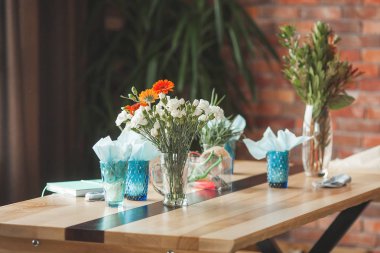 Floristics arka plan. Masanın üstünde çiçekler var. Laleler ve diğer bitkiler ile kompozisyon. Çiçek master-class.