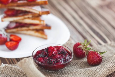 Sabah kahvaltısı. Çilek ve reçel ile tost. Ekmek ve sırdaş. Kremalı taze sıcak tostlar. Lezzetli ev yapımı tatlı.