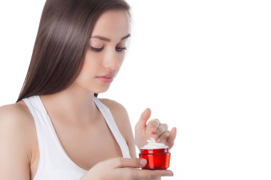 Yüz kremi süren genç ve güzel bir kadın. İzole edilmiş beyaz arka planda bir kadın. Yüz bakımı. Çekici bir bayanın yüz resmi..