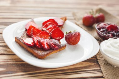 Sabah kahvaltısı. Çilek ve reçel ile tost. Ekmek ve sırdaş. Kremalı taze sıcak tostlar. Lezzetli ev yapımı tatlı.
