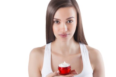 Yüz kremi süren genç ve güzel bir kadın. İzole edilmiş beyaz arka planda bir kadın. Yüz bakımı. Çekici bir bayanın yüz resmi..