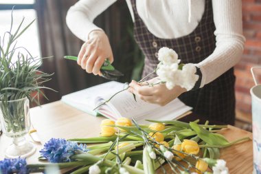 Çiçekçilik ustası bir kadın. Çiçekli kompozisyon hazırlayan genç bayan.. 