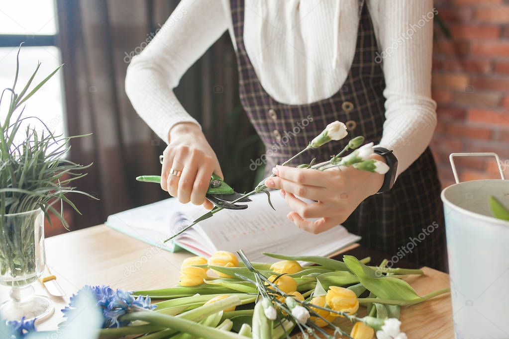 Woman on the master-class on floristics. Young lady making floral composition. 