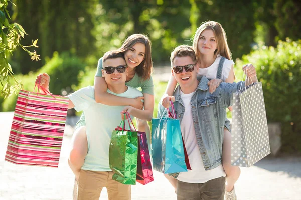 쇼핑을 매력적인 사람들의 야외에서 쇼핑백을 미소짓는 친구들 쾌활한 — 스톡 사진