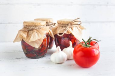 Kavanozdaki domatesler. Ev yapımı kurutulmuş domates. Geçici kapanma. Yaz ve sonbahar konserve yiyecekler. Baharat ve sebzelerle koru..