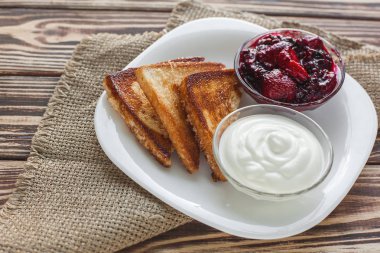 Sabah kahvaltısı. Çilek reçeli ile tost. Ekmek ve sırdaş. Kremalı taze sıcak tostlar. Lezzetli ev yapımı tatlı.