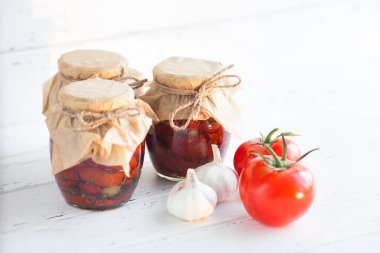 Kavanozdaki domatesler. Ev yapımı kurutulmuş domates. Geçici kapanma. Yaz ve sonbahar konserve yiyecekler. Baharat ve sebzelerle koru..