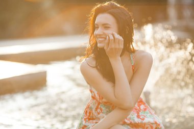 Dışarıda ki kadının güzellik portresi. Yaz aylarında çeşme yakınında Çekici şık genç kadın. Neşeli kızın closeup portresi.