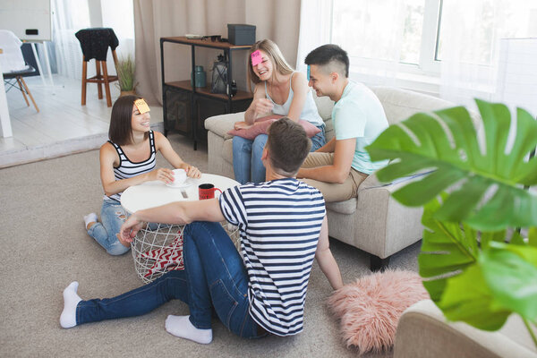 Группа молодых людей играет в игры в помещении. Активная молодость. Счастливые улыбающиеся люди веселятся. Студенты на праздниках.