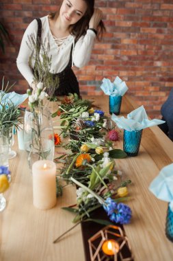 Elinde çiçek tutan çekici genç kadın. Çiçekçi kapalı.