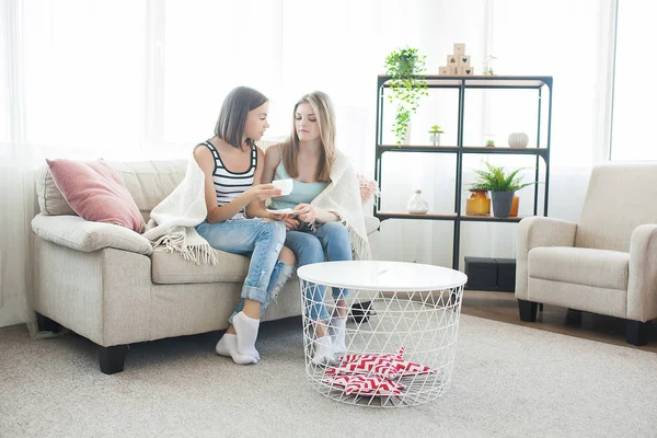 Woman sharing a problem with her friend. Girl`s conversation. Two women talking on the couch.