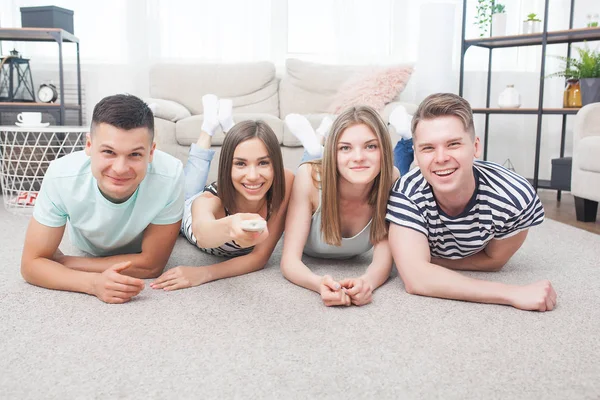 Group of young people watching tv. Emotional friends having fun and watching game indoors.