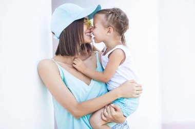 Çekici genç anne küçük kızını kucağına tutuyor. Mutlu bir aile dışarıda. Anne ve çocuk birlikte.