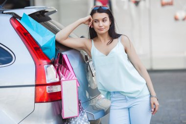 Perakende satışını arabaya koymaya çalışan kadın. Satın alma için yeterli alan yok. Alışveriş kızı. Alışverişte Alışverişkolik.