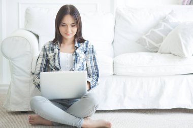 Dizüstü bilgisayarda çalışan çekici genç bir kadın. Pc'de kadın yazma. Bilgisayar ile evde genç bayan.