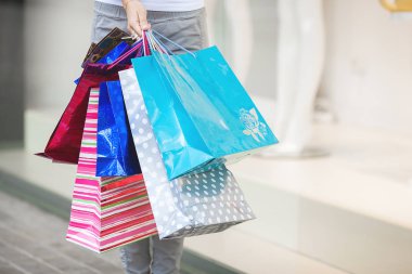 Alışveriş merkezinden alışveriş yapan çekici genç bir kadın. Marketin yanında alışveriş torbaları tutan bir kadın. Alışveriş yapan çekici bir kadın..