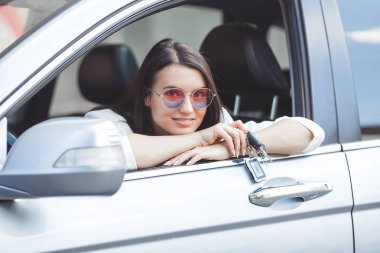 Genç çekici kadın yeni bir araba satın aldı. yeni otomobilden kadın tutma anahtarları.