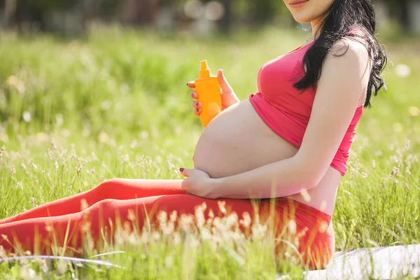 Giovane Donna Incinta Proteggendo Suo Stomaco Con Crema Solare Prima — Foto Stock