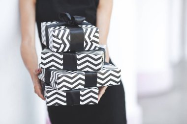 Şimdiki kutu. Siyah bir hediye. Siyah beyaz hediyeler tutan kadın.