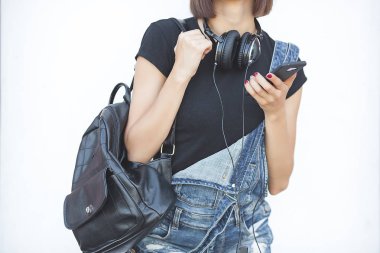 Araçlarla tarafsız arka planda olan kadın. Modern gençlik. Akıllı telefonda müzik dinleyen ve yazan genç kadın.