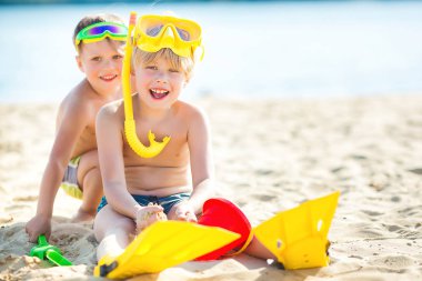 Sahilde eğlenen iki küçük çocuk. Deniz kıyısında oynayan komik çocuklar.