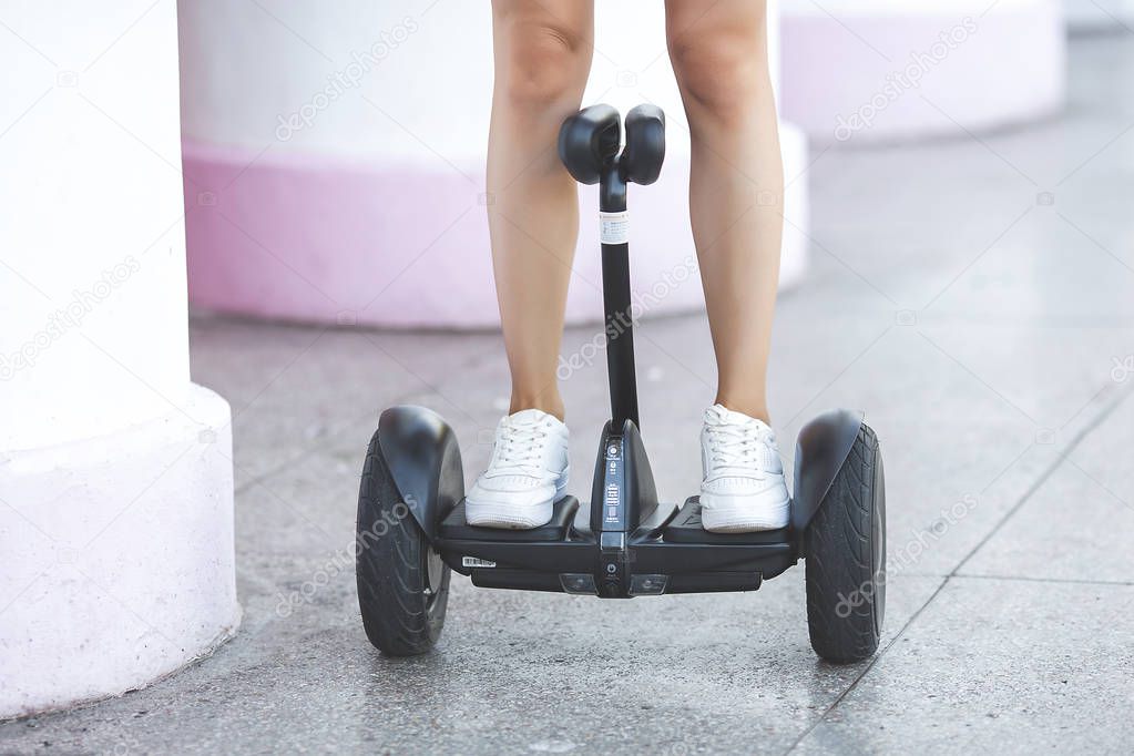 Young attractive woman skating on segway. Pretty female riding a gyroboard.