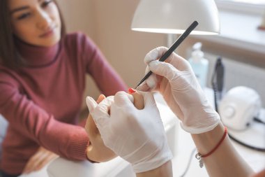 Manikürcü kuaförde manikür yapıyor. Usta servising müşterisi. Çivi bakım prosedürü.