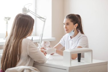 Manikürcü kuaförde manikür yapıyor. Usta servising müşterisi. Çivi bakım prosedürü.