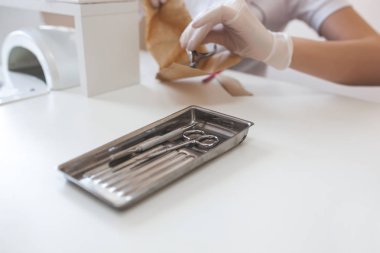 Manikürcü kuaförde manikür yapıyor. Usta servising müşterisi. Çivi bakım prosedürü.