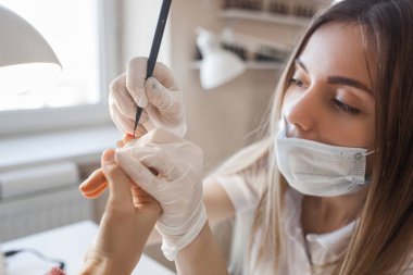 Manikürcü kuaförde manikür yapıyor. Usta servising müşterisi. Çivi bakım prosedürü.